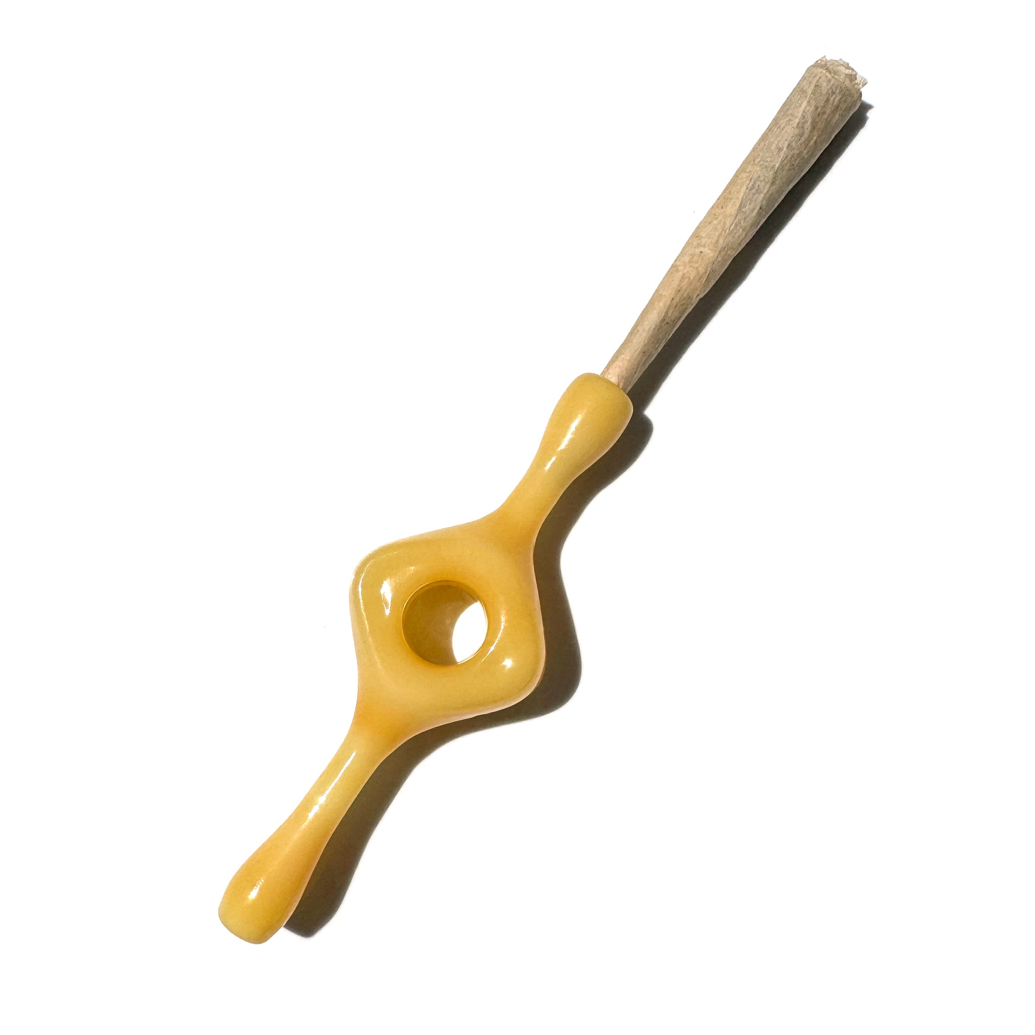 An opaque mustard glass joint holder with a hole in the middle designed for better grip and a smoother smoke. 