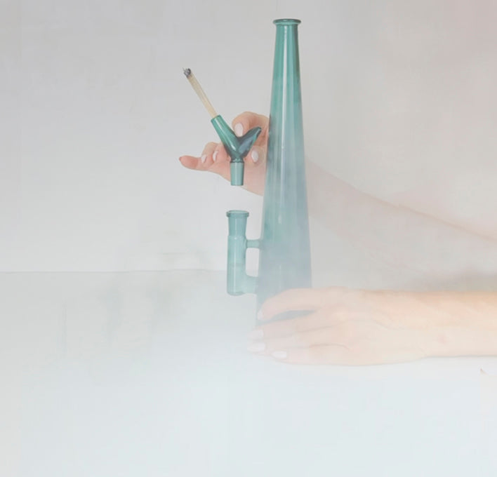 Hazy, smoke-filled image as the teal JoinBowl™ is in use with lit joint